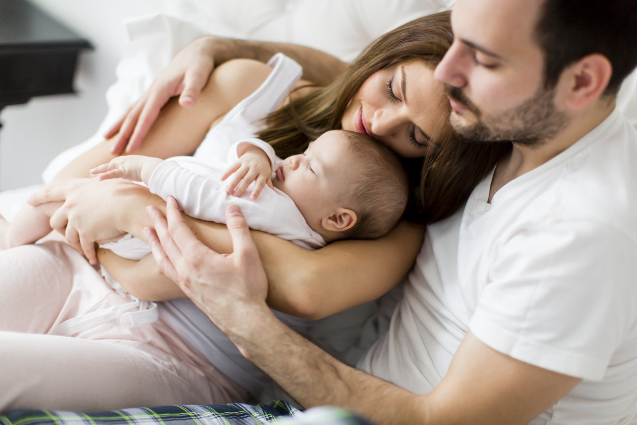padres abrazando a su bebé